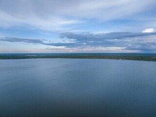 Big lake with green shores in bright sun light, aerial landscape. Recreation concept. Aerial view