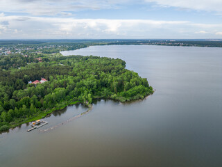 Big lake with green shores in bright sun light, aerial landscape. Recreation concept. Aerial view