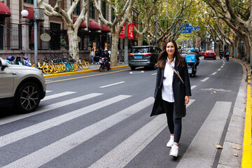 Sweet pretty woman wear dark jacket crossing road in Shanghai 