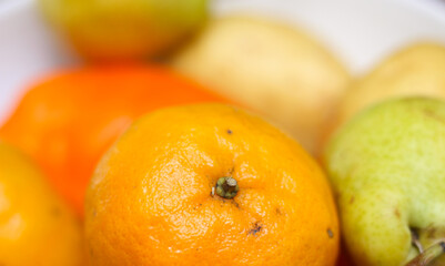 fruits and vegetables. tangerine over other vegetables. tangerine with orange bell pepper, pear and potato. tangerine with selective focus.