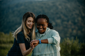 Nature's Fitness Tracker: Surrounded by towering trees, two women embrace the benefits of outdoor exercise, their smartwatches recording valuable data, such as distance, pace, and elevation gain.