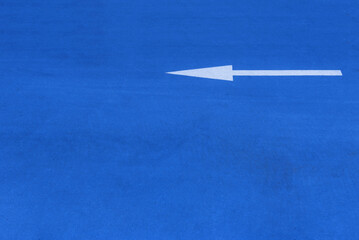 White painted indicator arrow on blue surface