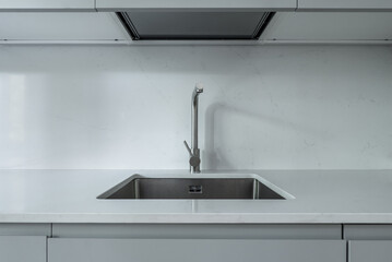 stainless steel kitchen sink embedded in a polished white stone