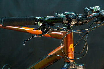 Handlebars of a mountain bike close-up on a black background in the studio. Bicycle repair,...