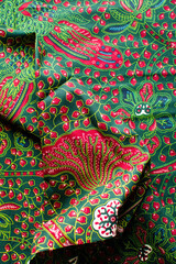 top view of red and green ankara fabric, flatlay of nigerian wax cloth, red and green ankara material on a table