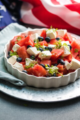 Patriotic salad idea with blueberries, feta and watermelon  on gray background, USA Independence Day, Top view