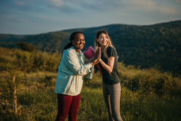 Unity in Nature: Against a backdrop of vibrant foliage, two women of different races come together to embrace the healing power of yoga and forge a bond of unity.