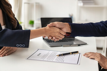 Job interview. Two businessmen shake hands to submit resume documents. HR manager shakes hands congratulating job candidates for successful job application close up pictures