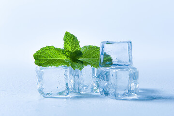 Ice cubes and fresh mint leaves, isolated on blue background	