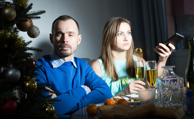 Young offended couple having problems in relationship, ignoring each other on Christmas night