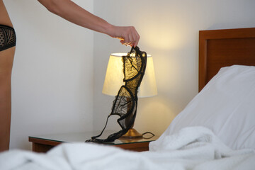 Woman's black lace bra on the lamp in the hotel room