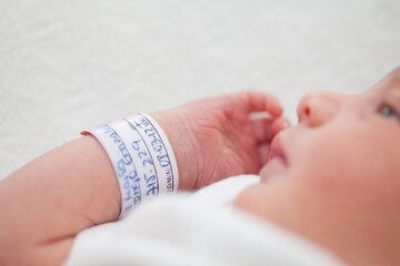 Closeup of a newborn arm and bracelet at hospital on the day of her birth