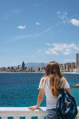 Fototapeta na wymiar Carefree young tourist woman in sun hat enjoying sea view at Balcon
