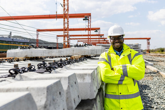 Portrait Of Civil Engineer Holding Arms Crossed At Road And Railroad Construction Site.