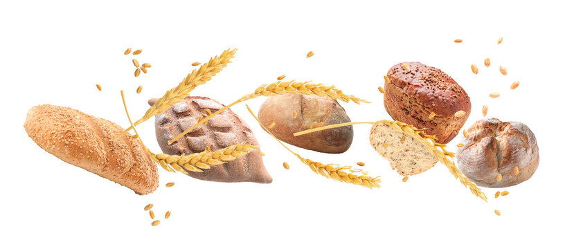 Flying fresh bread with spikelets and seeds on white background
