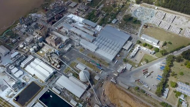 Drone flight tilt movement over pulp and paper mill on river coast