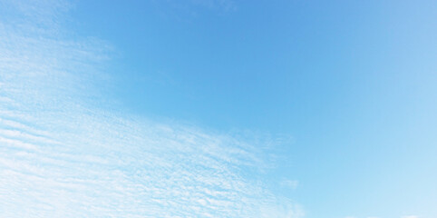 Blue sky background and white clouds soft focus, and copy space horizontal shape.