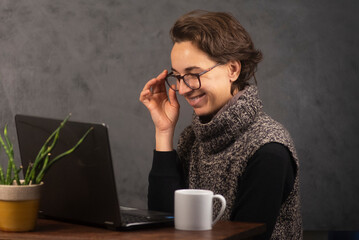 Mujer joven trabajando en la oficina con  laptop y tomando café