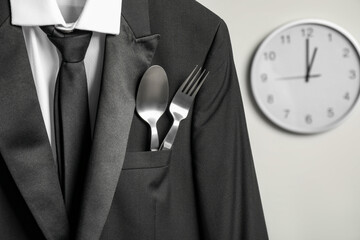 Cutlery in breast pocket of men`s jacket indoors, closeup. Business lunch concept