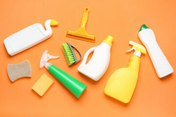 Different cleaning supplies on orange background - obrazy, fototapety, plakaty