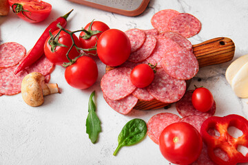 Different ingredients for preparing pizza on white marble background