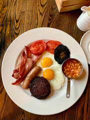 Traditional Irish breakfast with eggs, Irish bacon, black pudding, grilled tomatoes and beans.
