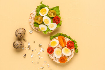 Rice crackers with quail eggs, tomatoes and lettuce on beige background