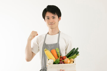 Fototapeta na wymiar 野菜を持ってガッツポーズする男性