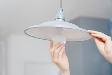 電球を交換する女性の手元