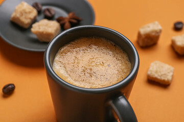 Cup of hot espresso on orange background