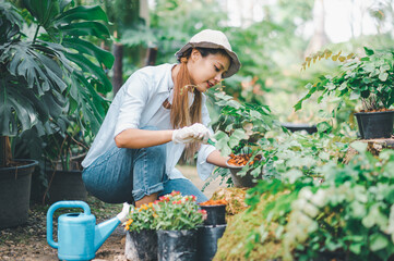 Young women doing hobbies taking care of plants, watering, shoveling flowers. In the garden during the break from work