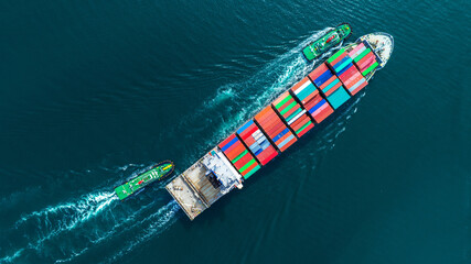 Aerial top view of cargo ship carrying container and running with tug boat for import export goods from cargo yard port to custom ocean concept freight shipping by ship .