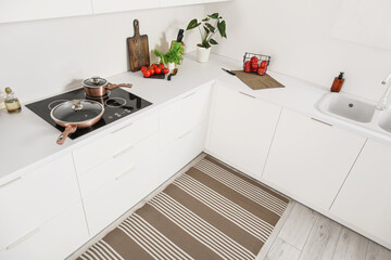 Stylish striped rug in interior of modern kitchen