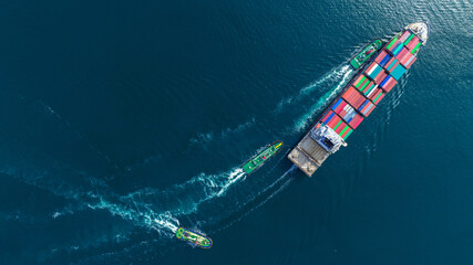 Aerial top view of cargo ship carrying container and running with tug boat for import export goods from cargo yard port to custom ocean concept freight shipping by ship . - obrazy, fototapety, plakaty