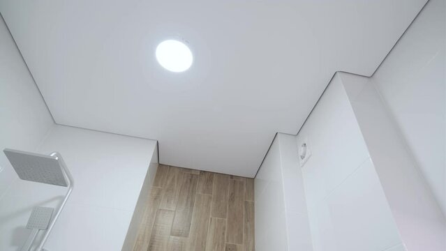 White stretch ceiling in a stylish bright bathroom. Modern design
