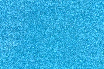 Fototapeta na wymiar Rough textural surface of a blue wall. Background or backdrop. Blank for design