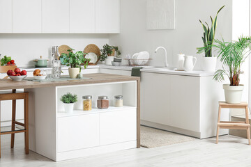 Interior of modern kitchen with island table and white counters