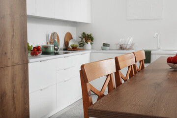 Wooden island table in interior of modern kitchen
