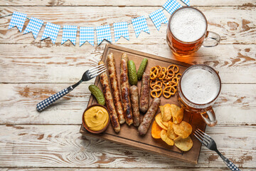 Mugs of cold beer and different snacks on light wooden background. Oktoberfest celebration