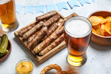 Glass of cold beer and different snacks on light background. Oktoberfest celebration