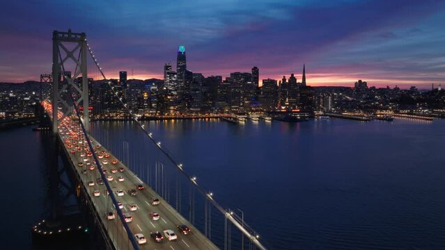 Downtown San Francisco at pink sunset. Scenic San Francisco skyline panorama. Aerial downtown at night scene. Beautiful urban landscape of bay city dusk. City lights in purple sunset light California