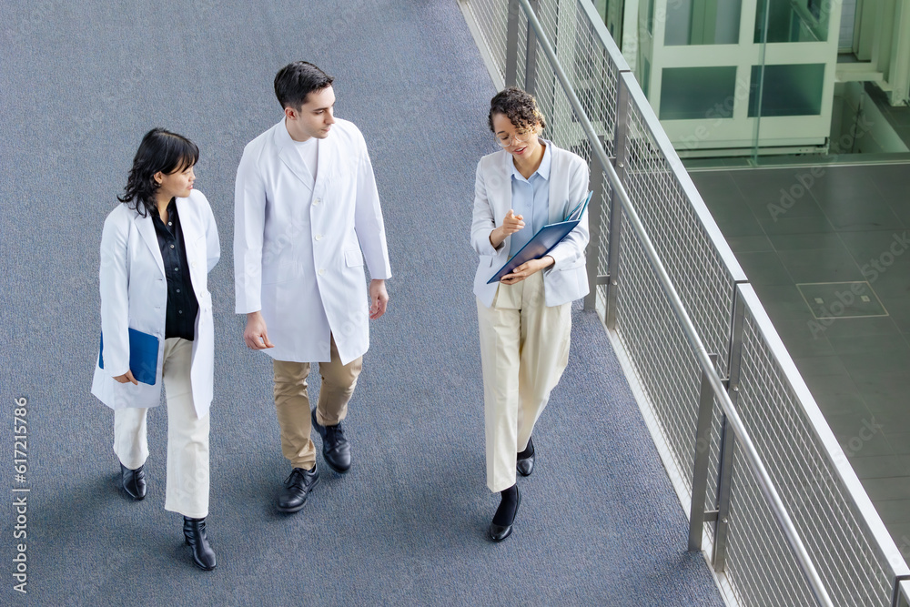 Poster a multinational group having a conversation in the lobby. people in white coats and sales staff. hig