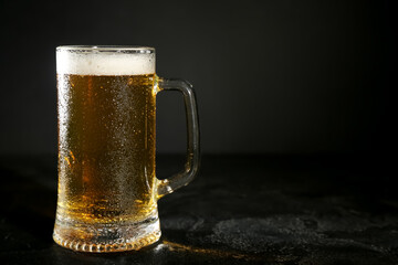 Mug of cold beer on dark background, closeup