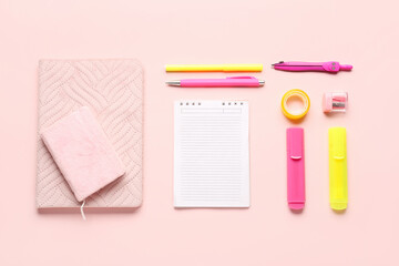 Notebooks with different school stationery on pink background