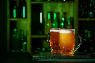 Mugs of fresh beer on table in bar