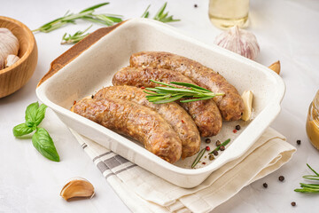 Baking dish of tasty homemade sausages on grey background