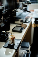 Coffee in a glass with ice on the bar counter.