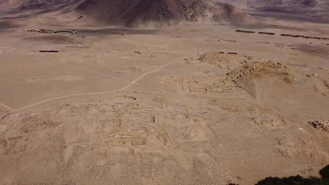 Aerial video of the ancient city of Caral. One of the oldest cities of the world. Drone orbits above the archaeological site. Located in the Supe valley in Lima, Peru. Recorded in 4k quality.
