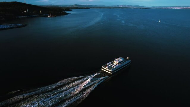 Aerial view following a car-ferry heading out on the Oslofjord, evening in Norway