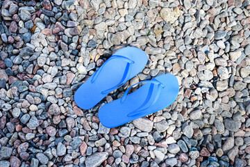 Blue flip-flops on rocky beach
